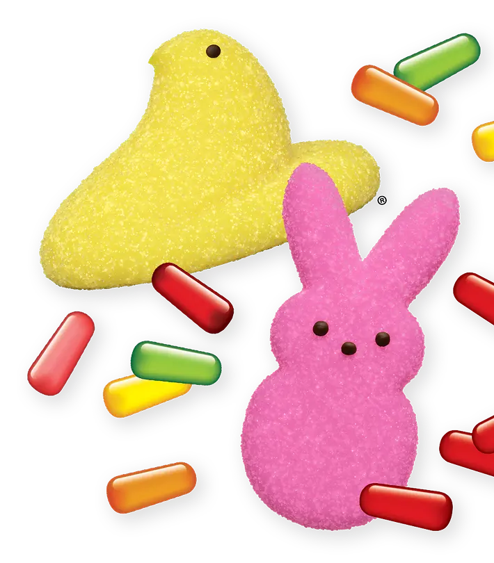 Yellow chick and pink bunny marshmallow Peeps surrounded by colorful, pill-shaped candies on a black background.