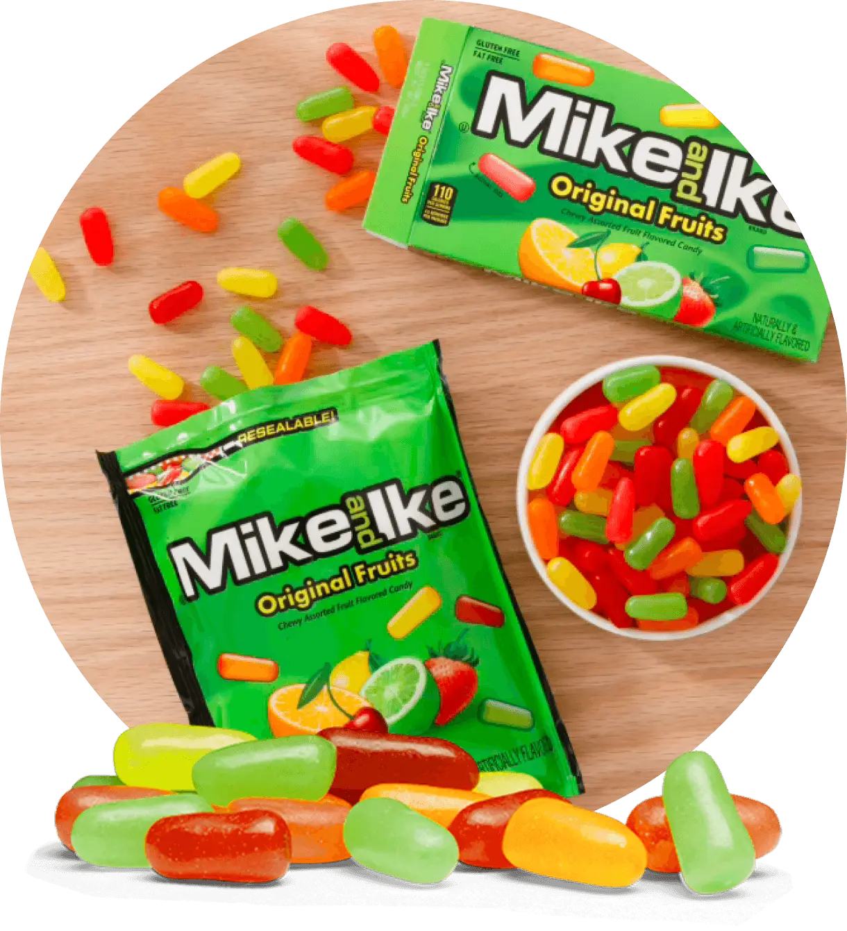 A bag and box of Mike and Ike Original Fruits candies with colorful pieces scattered on a wooden surface and in a small white bowl.